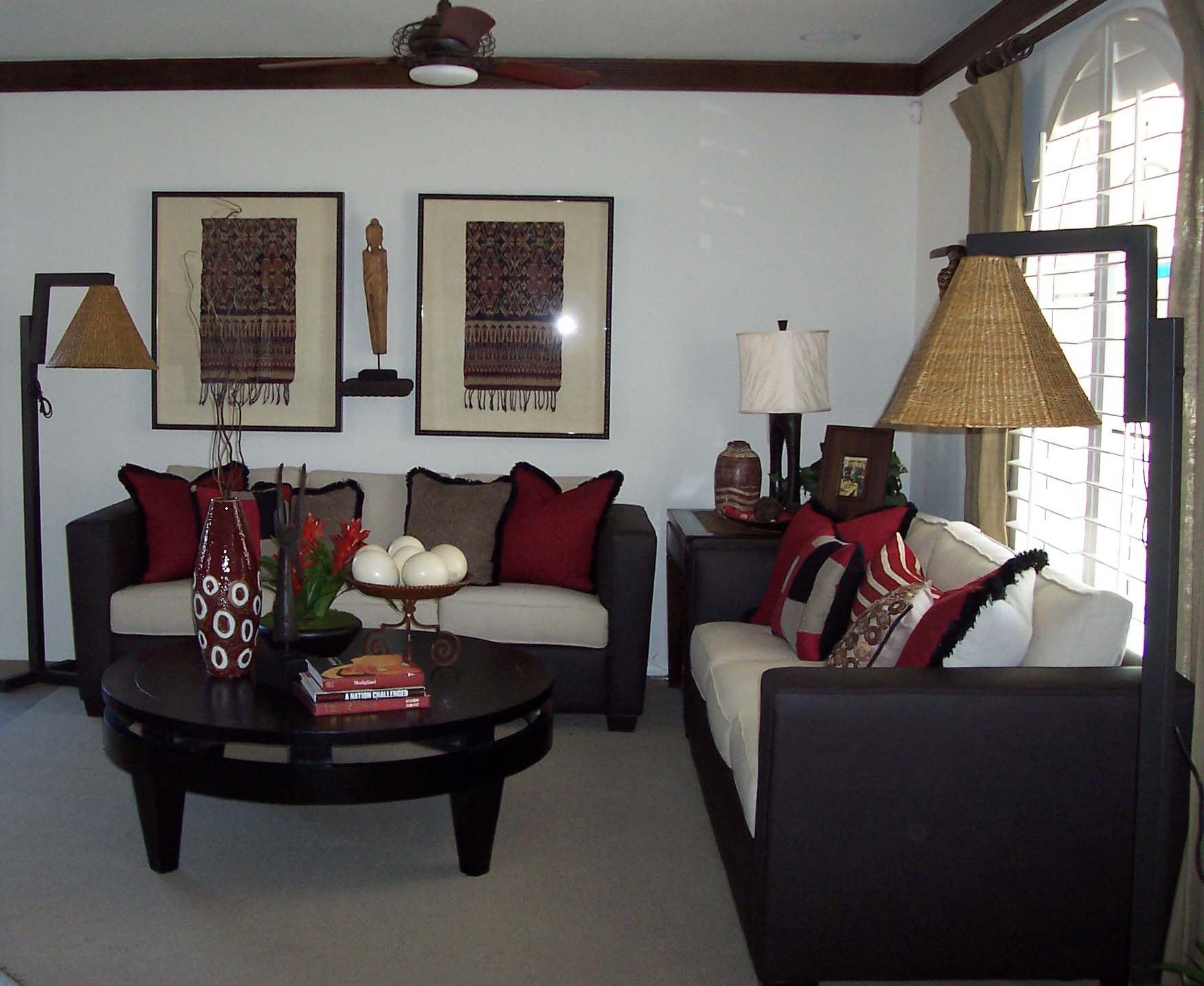 Living room with dark sofas, burgundy accents and global-inspired wall art
