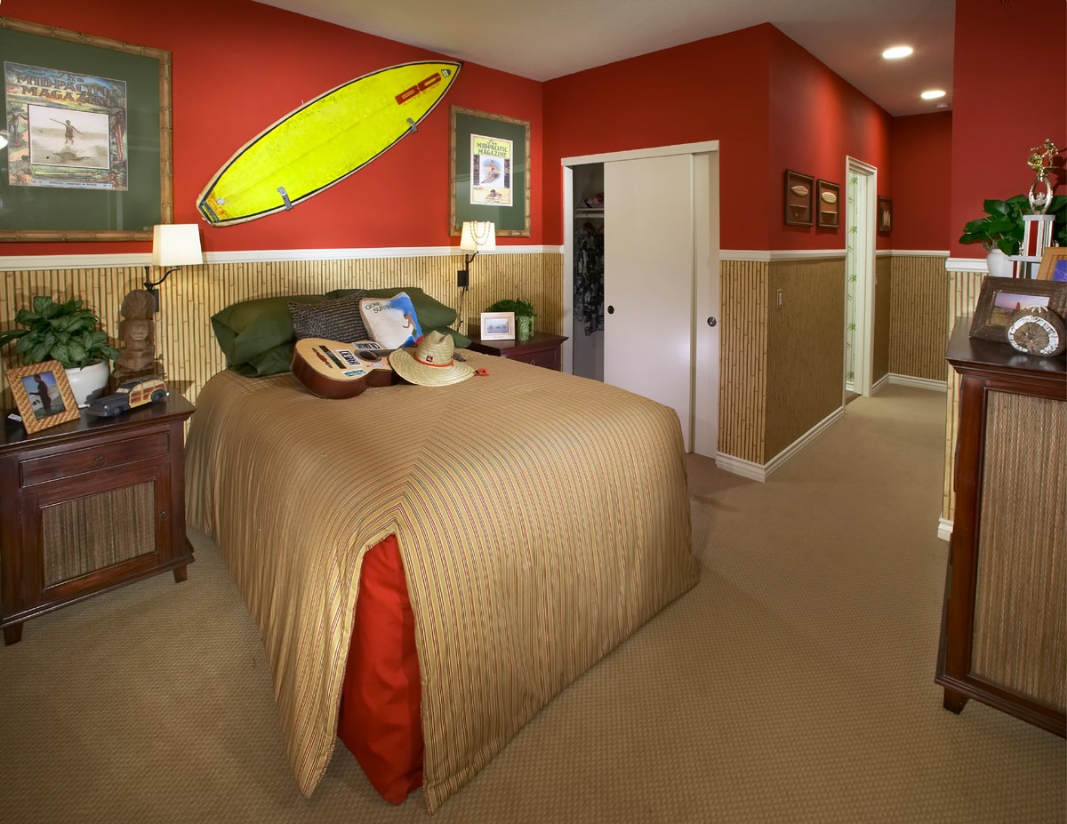 Surf-themed bedroom with a bright yellow surfboard and bamboo wall paneling