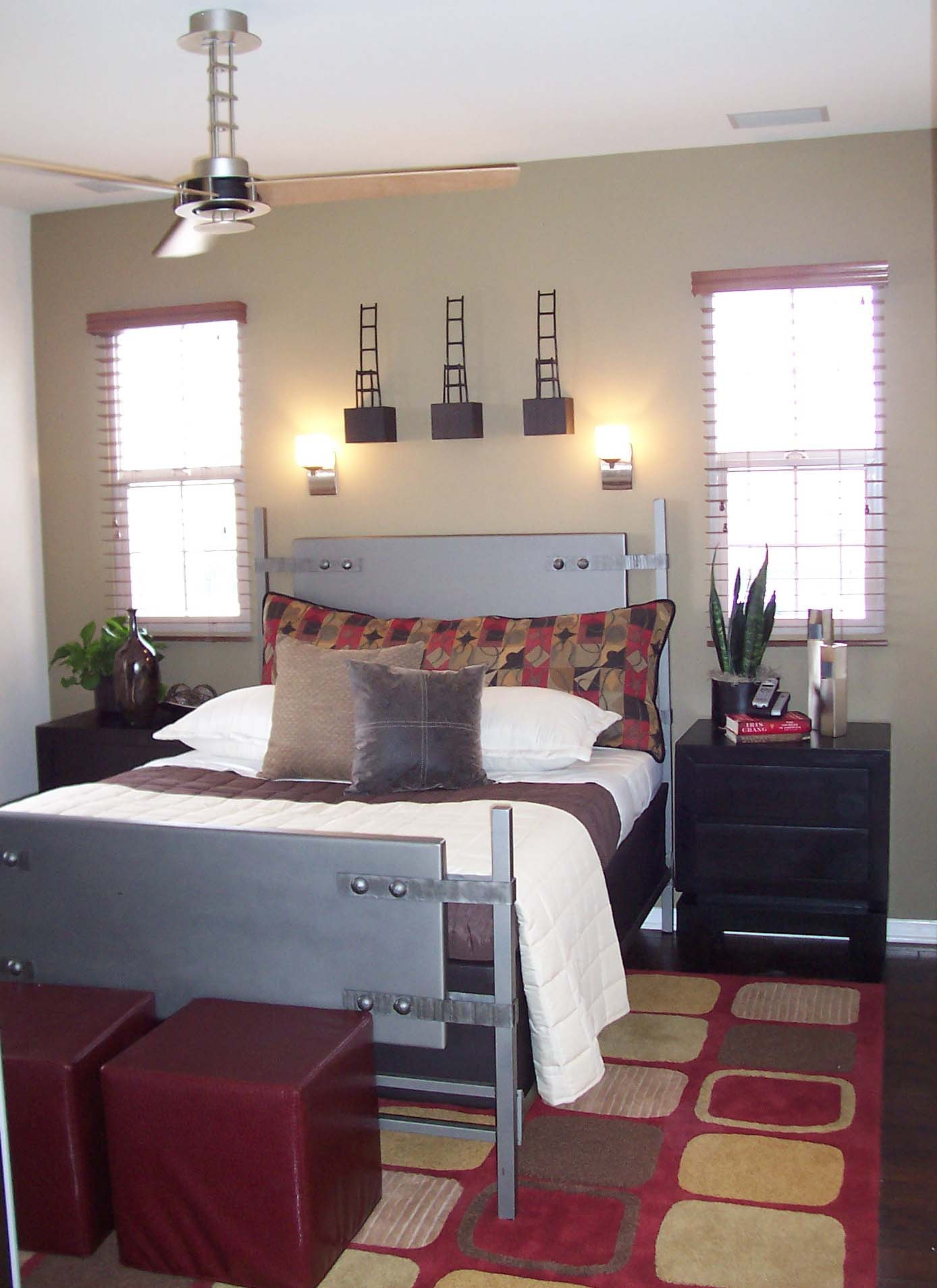 Bedroom with a metal bed frame, geometric rug, and warm neutral walls
