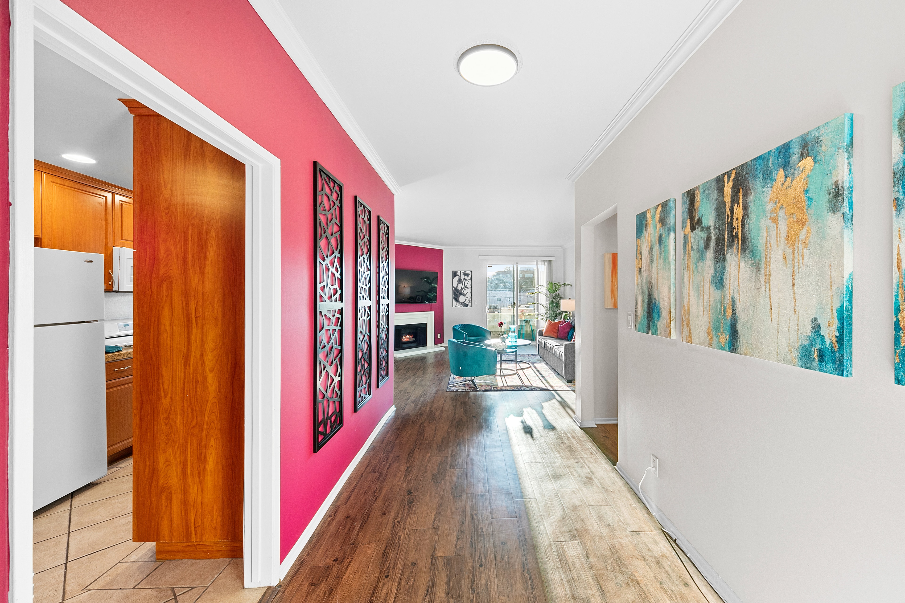 Fuchsia hallway with graphic wall panels and abstract artwork