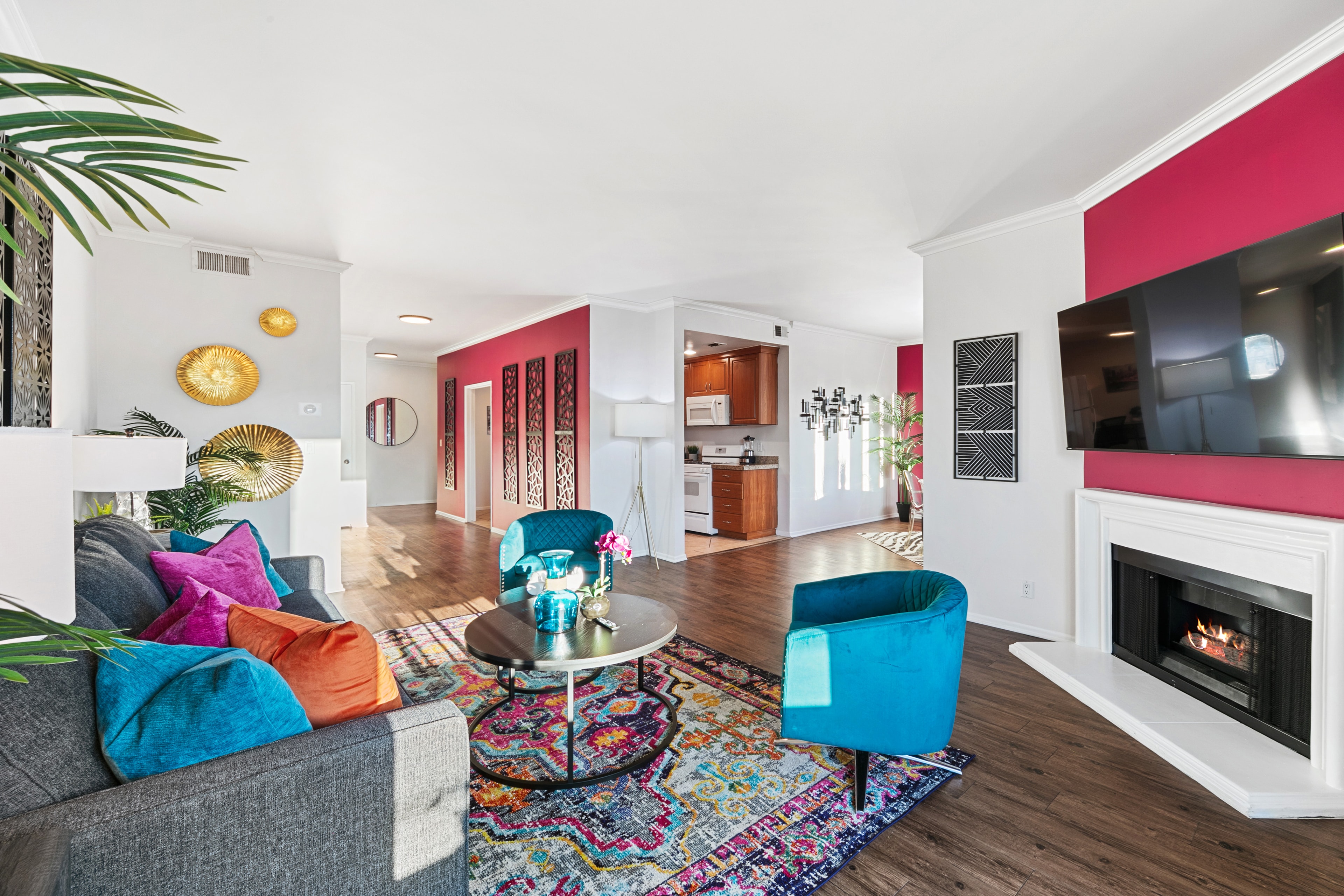Living room view toward the kitchen with fuchsia walls and teal seating