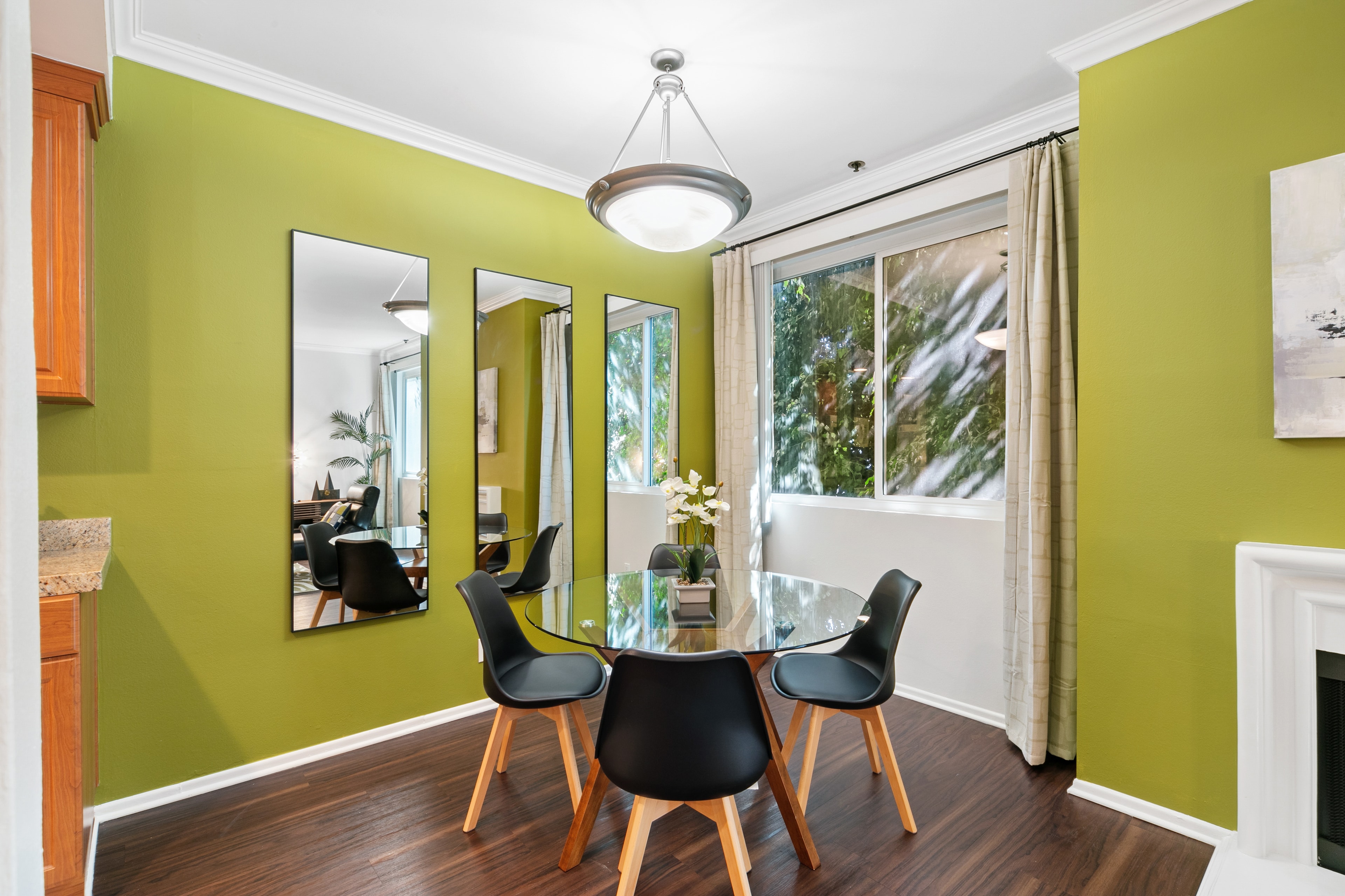 Dining room with kiwi-green walls, glass table, and black chairs