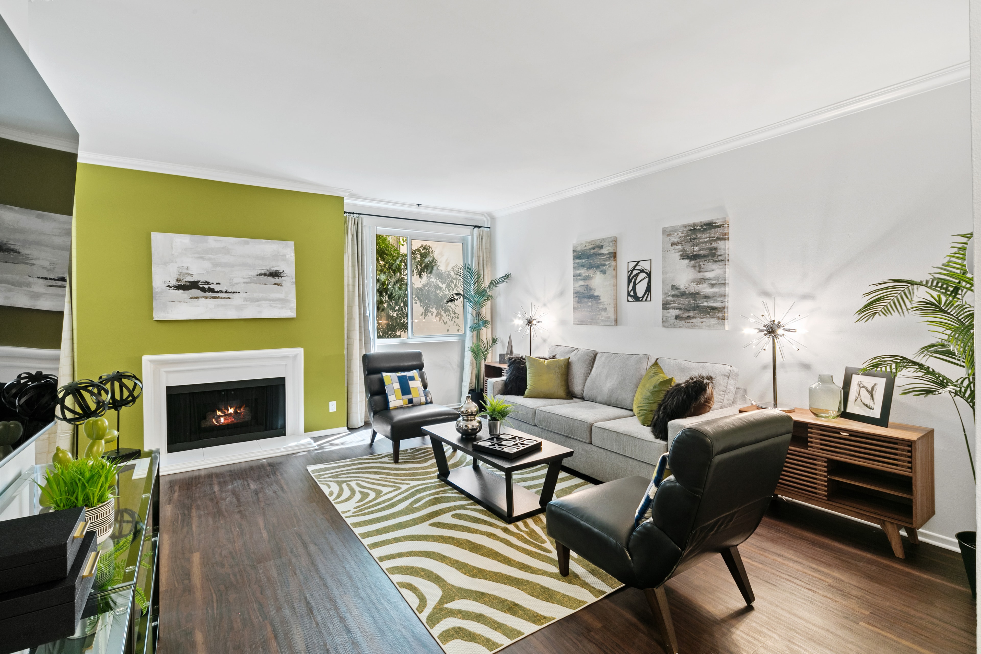Living room with a kiwi-green fireplace wall, gray sofa, and black lounge chairs