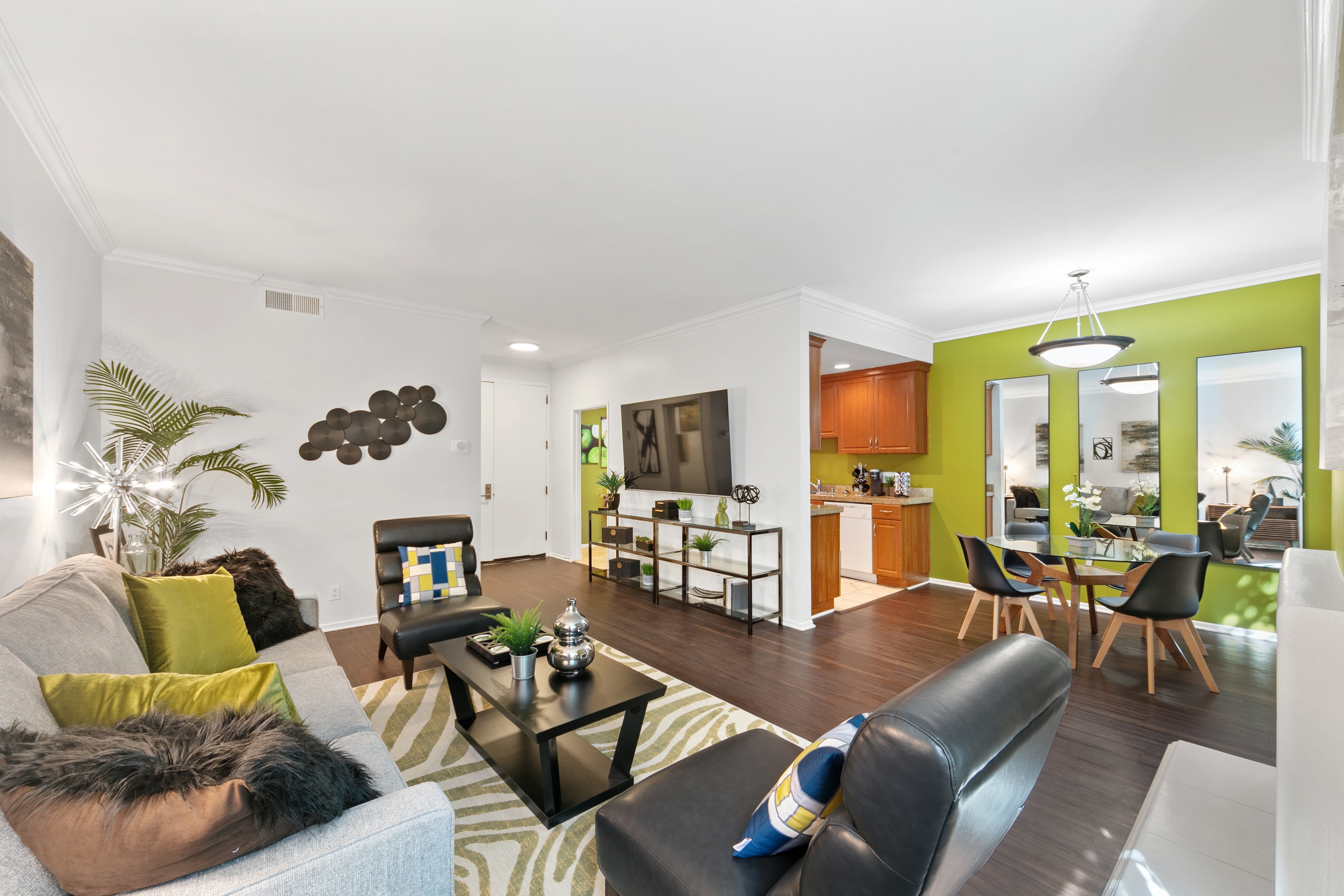 Living and dining area with kiwi-green walls and warm wood cabinetry