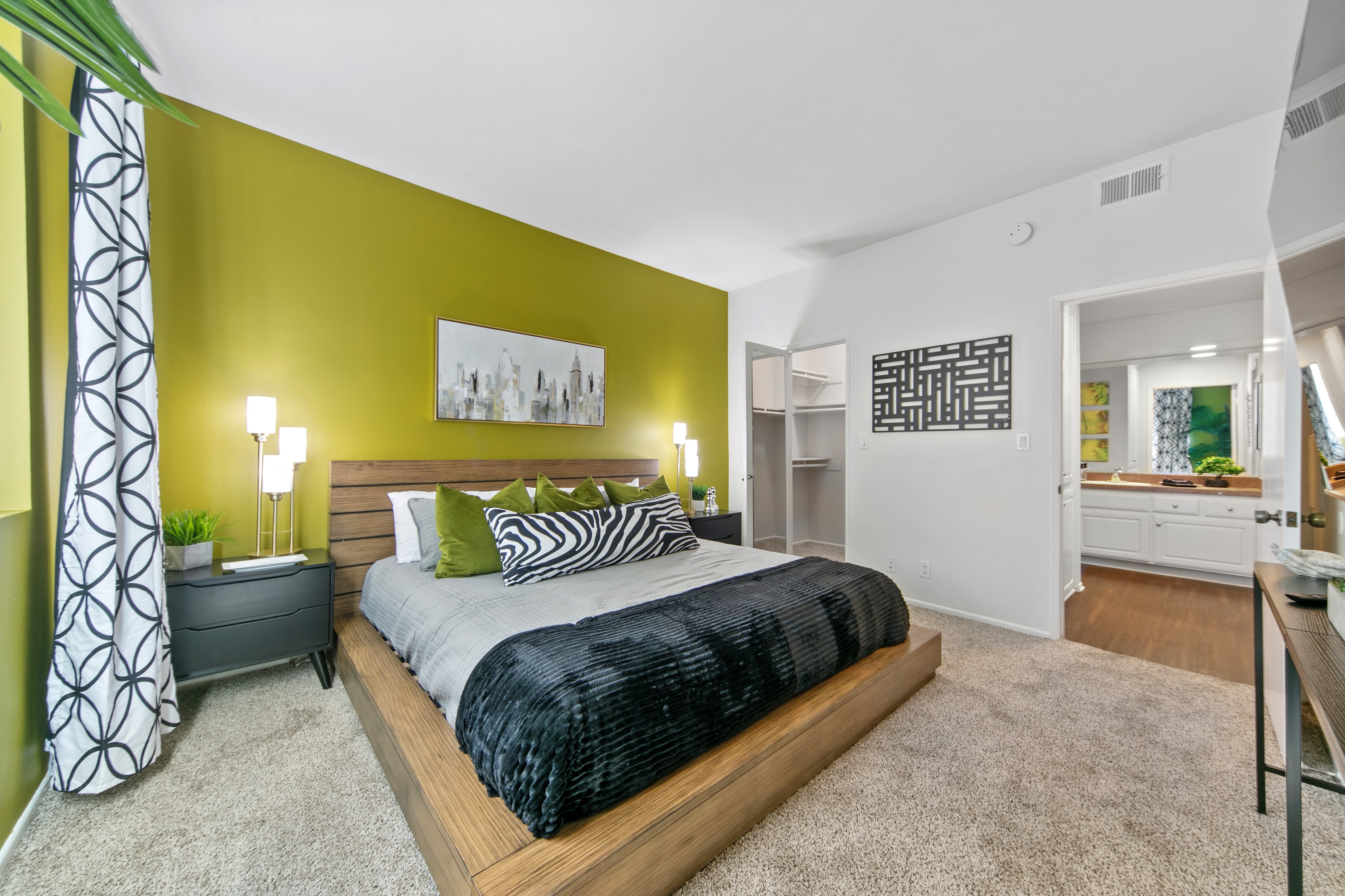 Primary bedroom suite with kiwi-green walls, a wood bed, and an adjoining bath