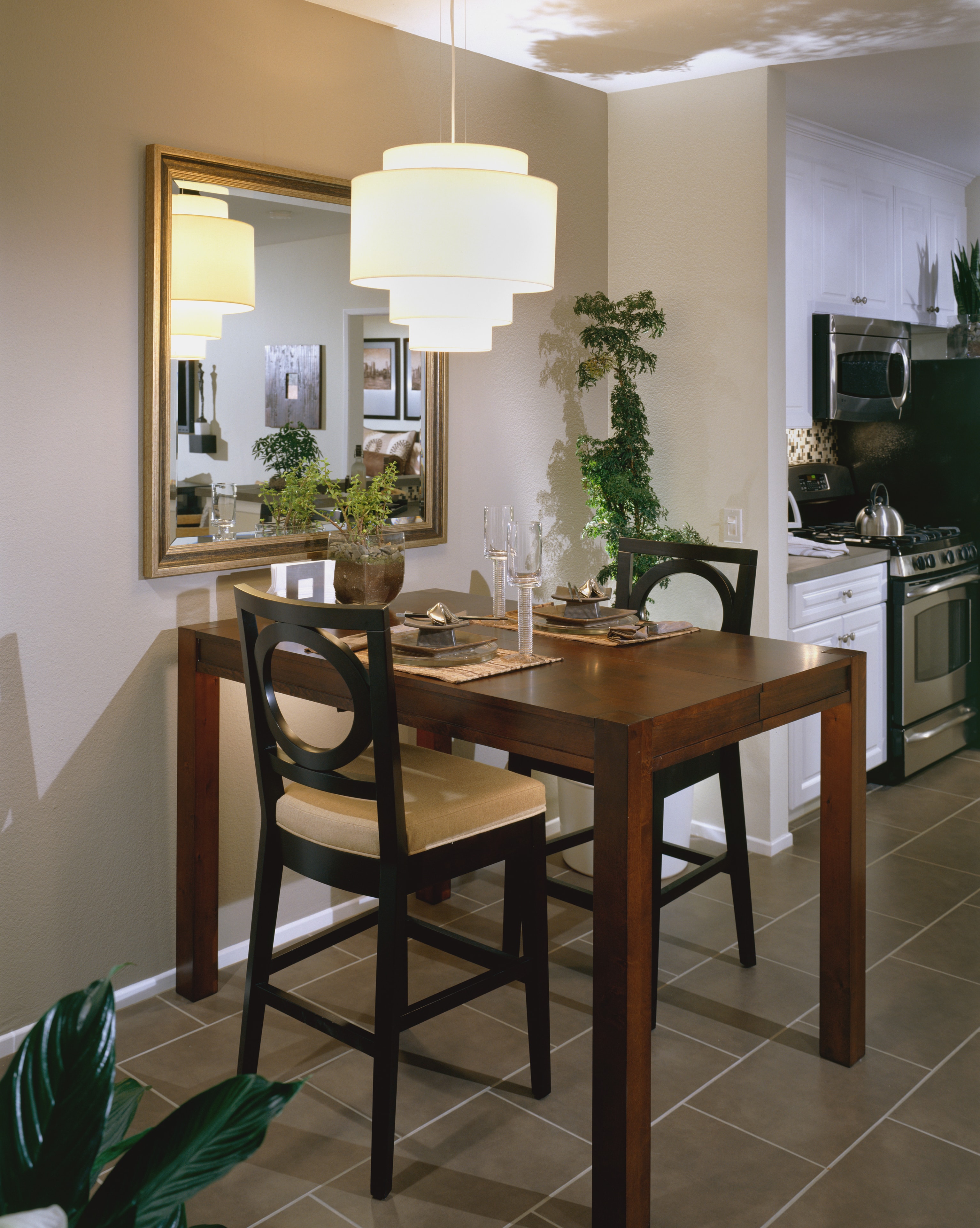 Wabi-sabi dining room with dark wood table, layered pendant lights, and botanical accents