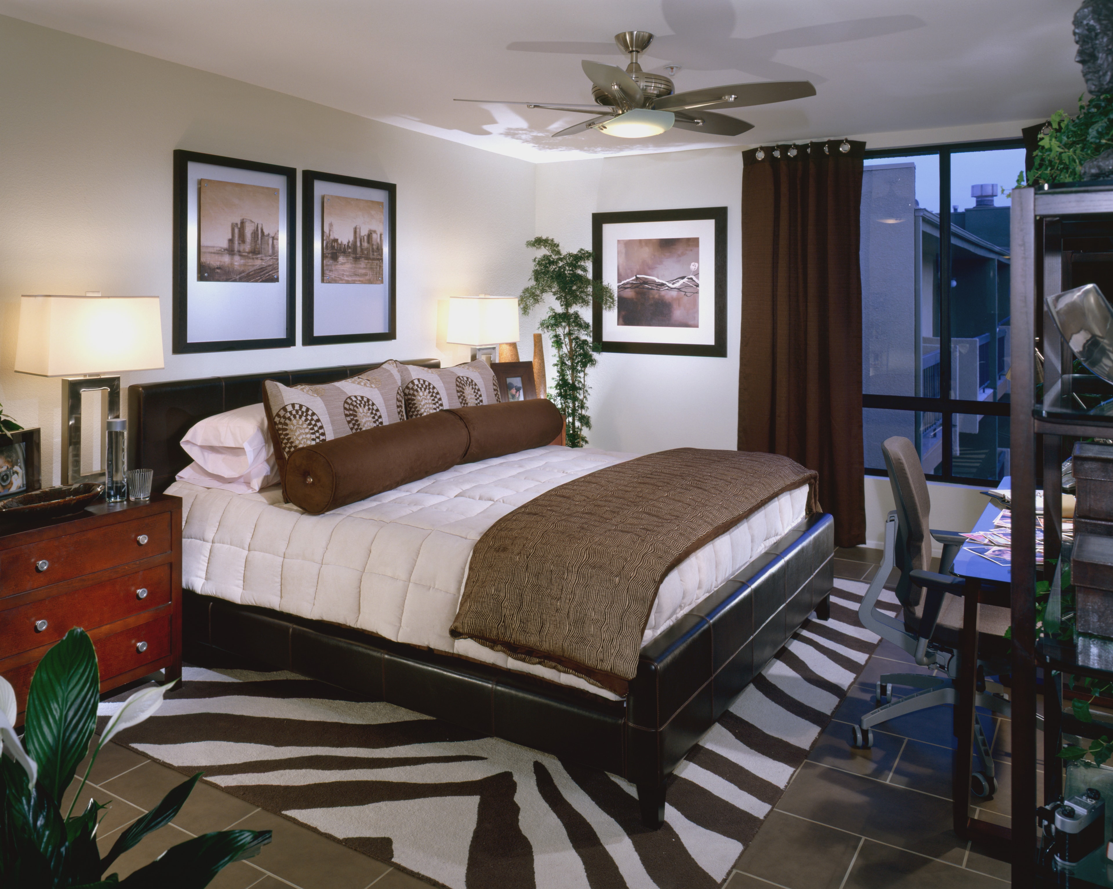 Primary bedroom with dark wood furnishings, neutral bedding, and patterned rug
