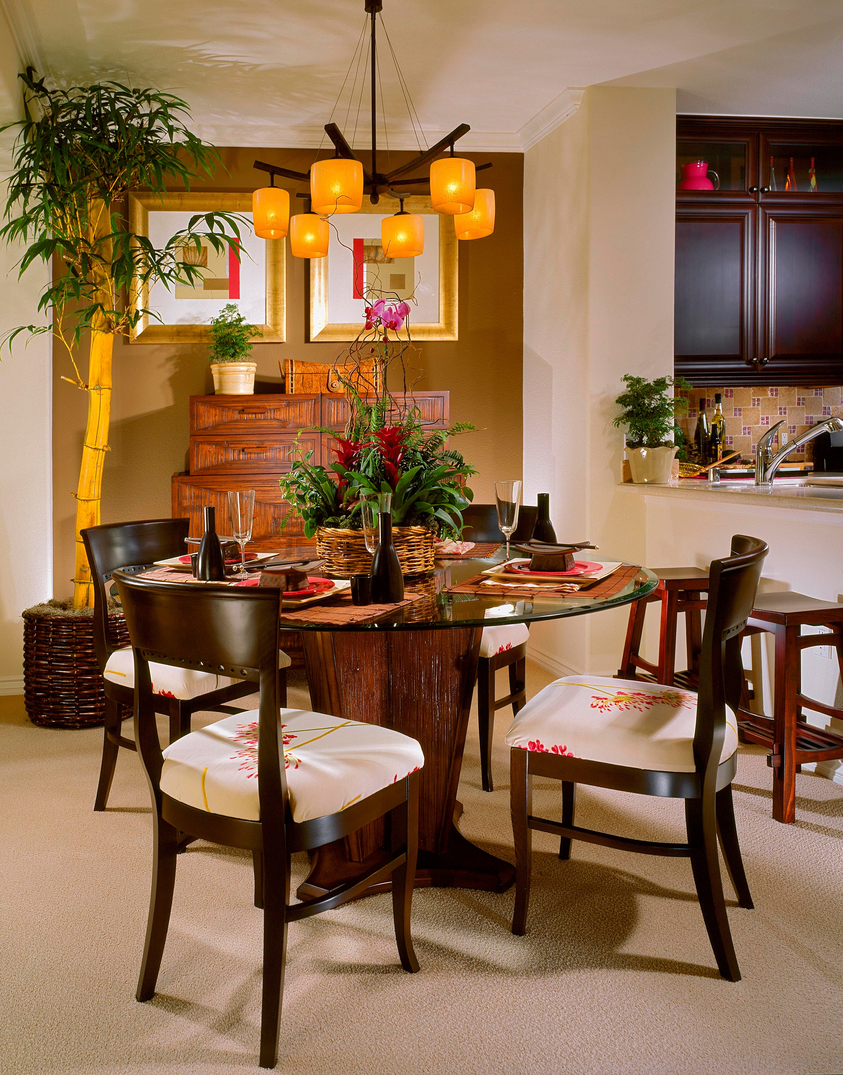 Asian-inspired dining room with sculptural amber pendant lights, bamboo, and dark wood furniture