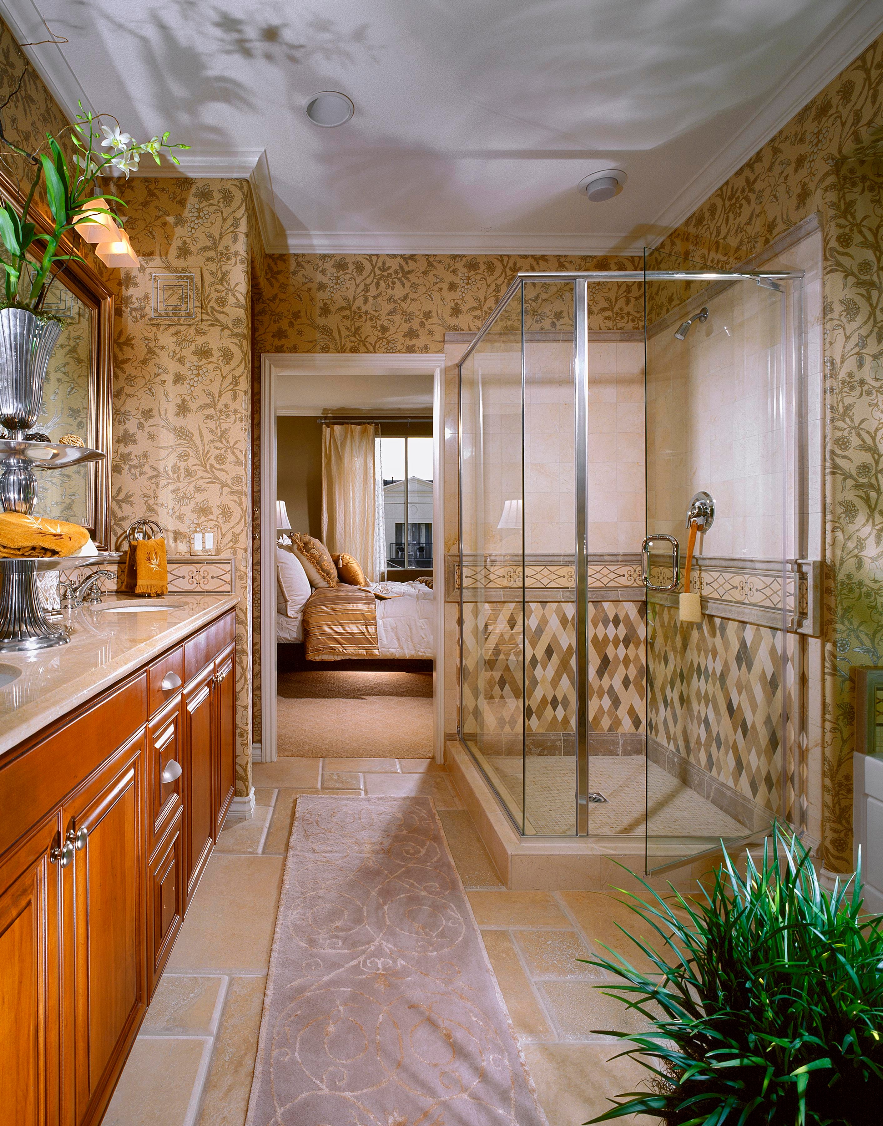 Bathroom with botanical wallpaper, wood vanity, patterned tile shower, and glass enclosure
