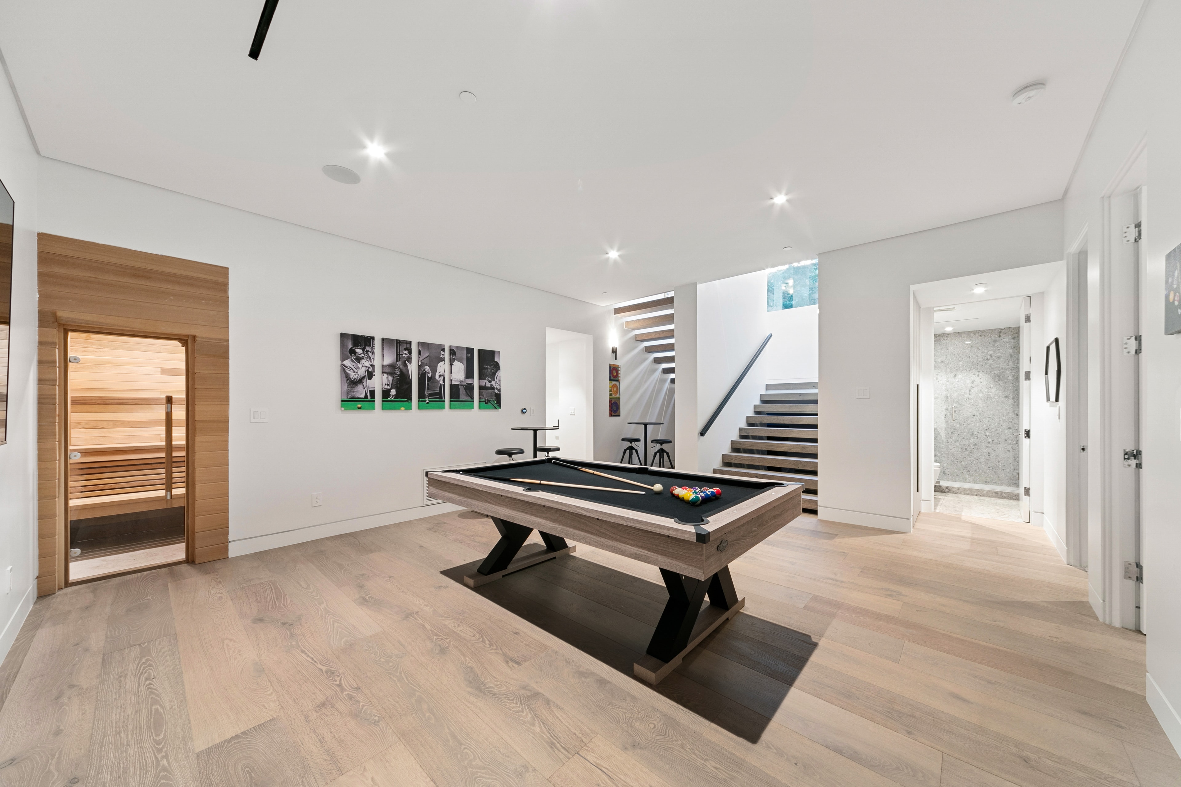 Bright basement recreation room with pool table and sauna