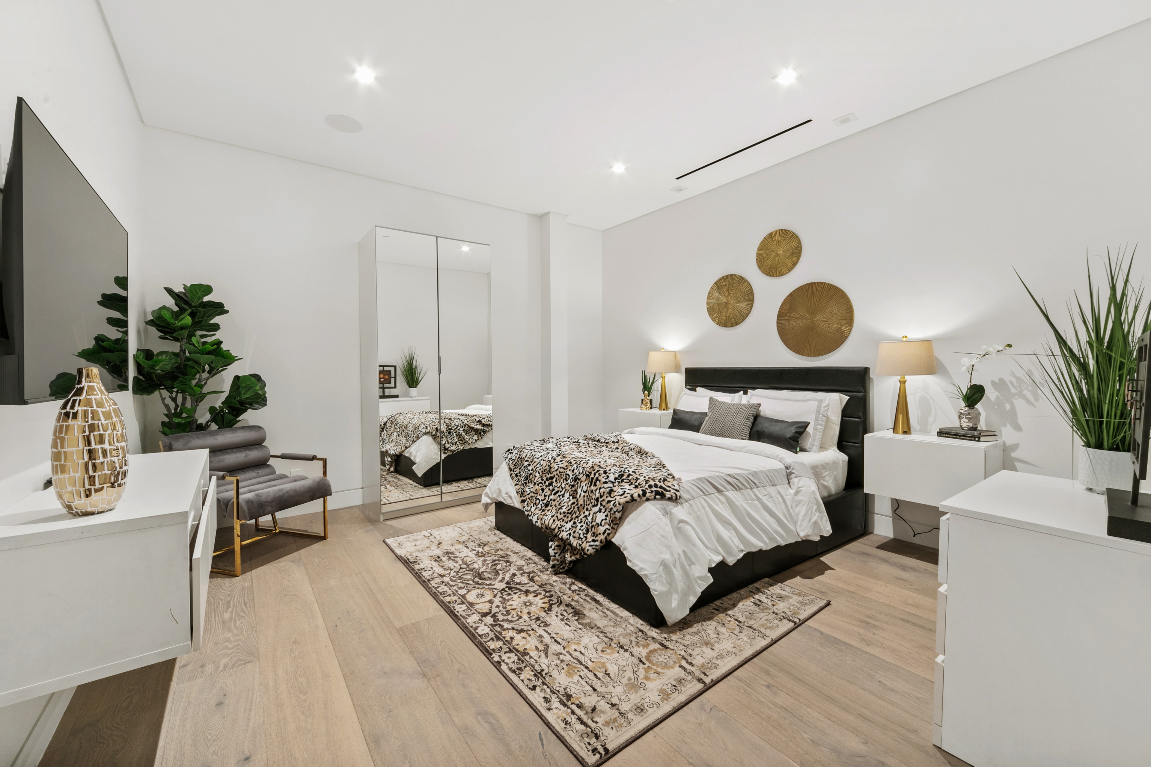 Tailored guest bedroom with black accents, gold decor, and patterned textiles