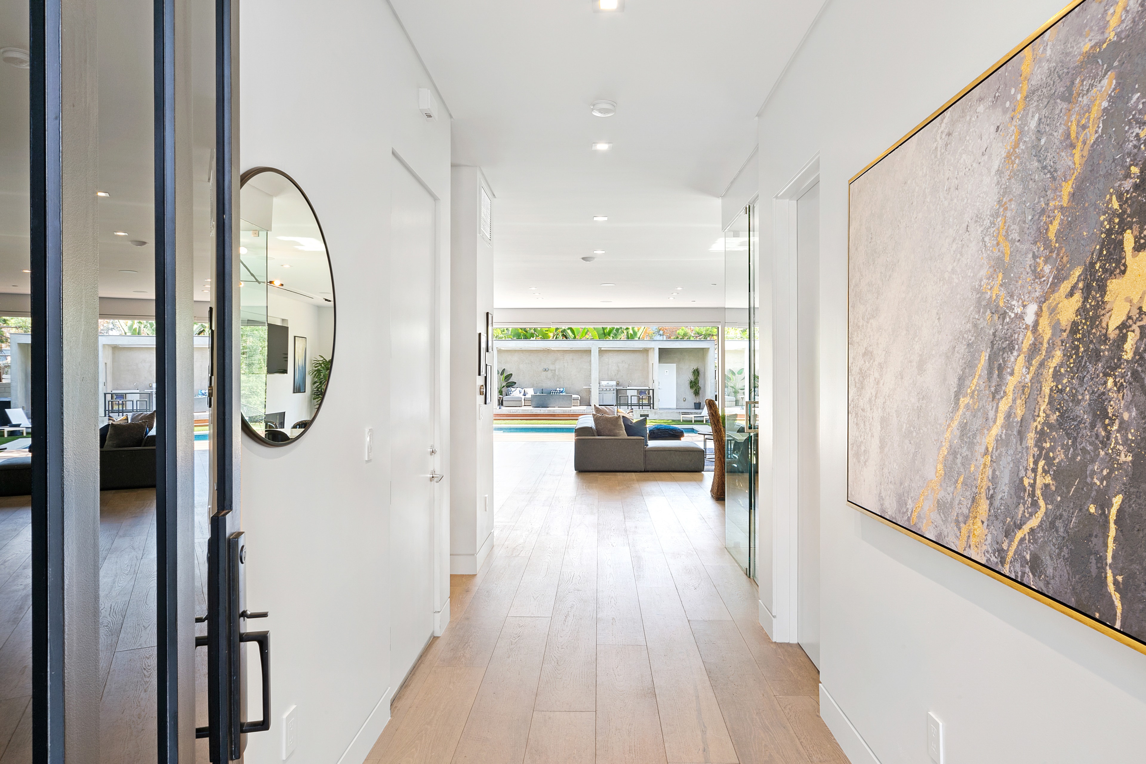 Bright entry hallway with large abstract artwork and pool view