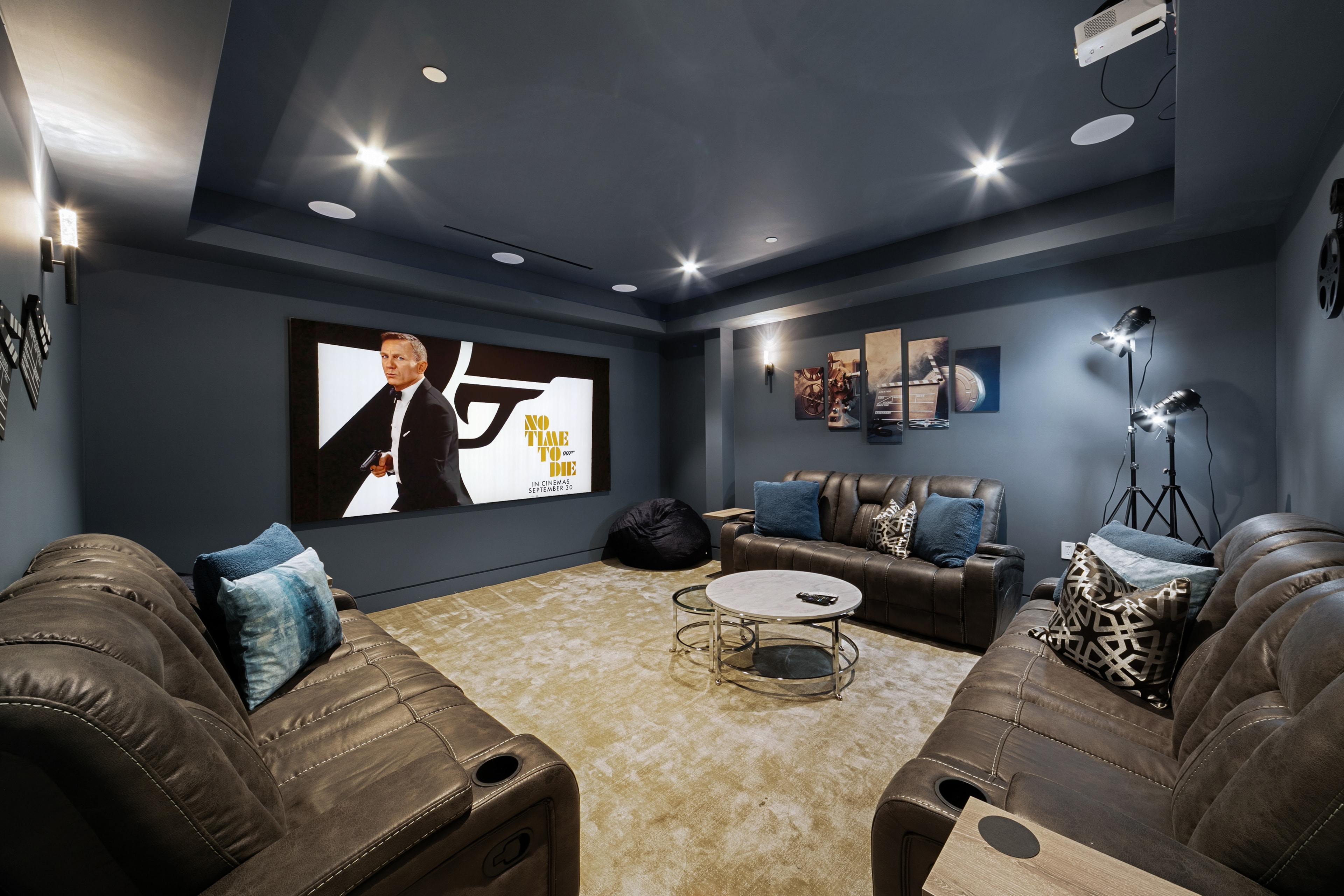 Dark home theater with leather seating and projection screen