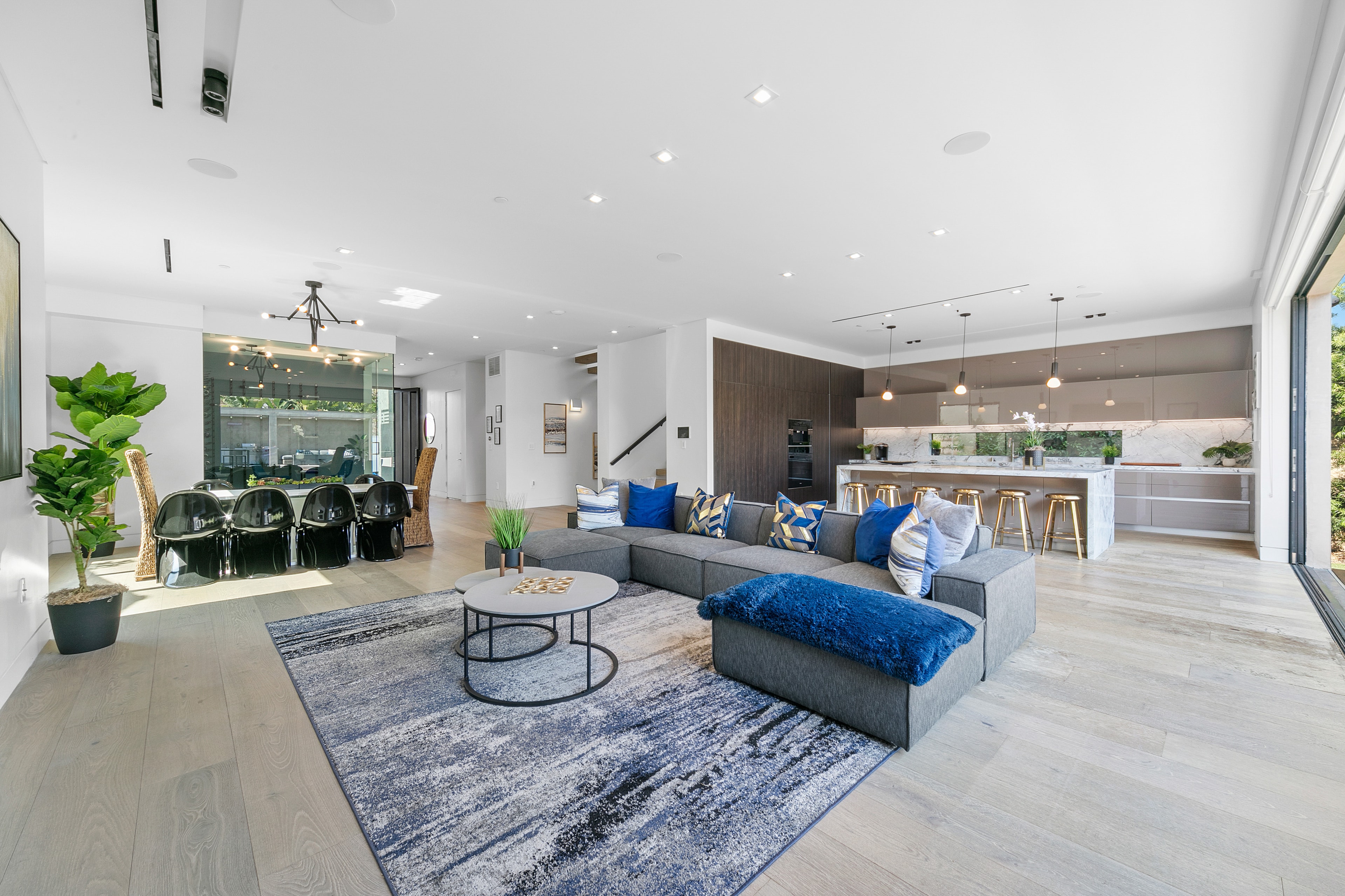 Open-plan living room, dining area, and kitchen with tailored blue accents