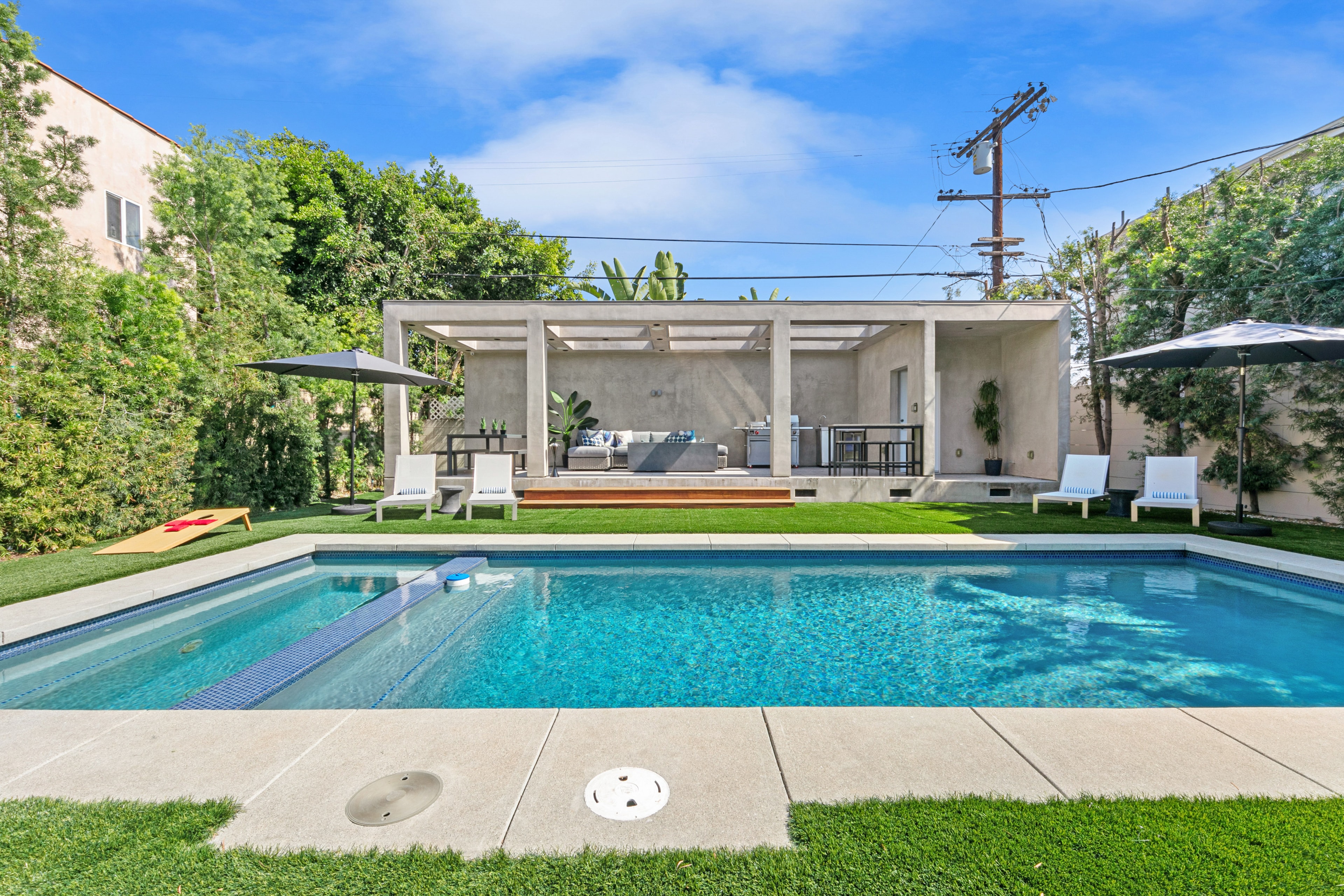 Backyard pool with covered outdoor pavilion and lounge seating