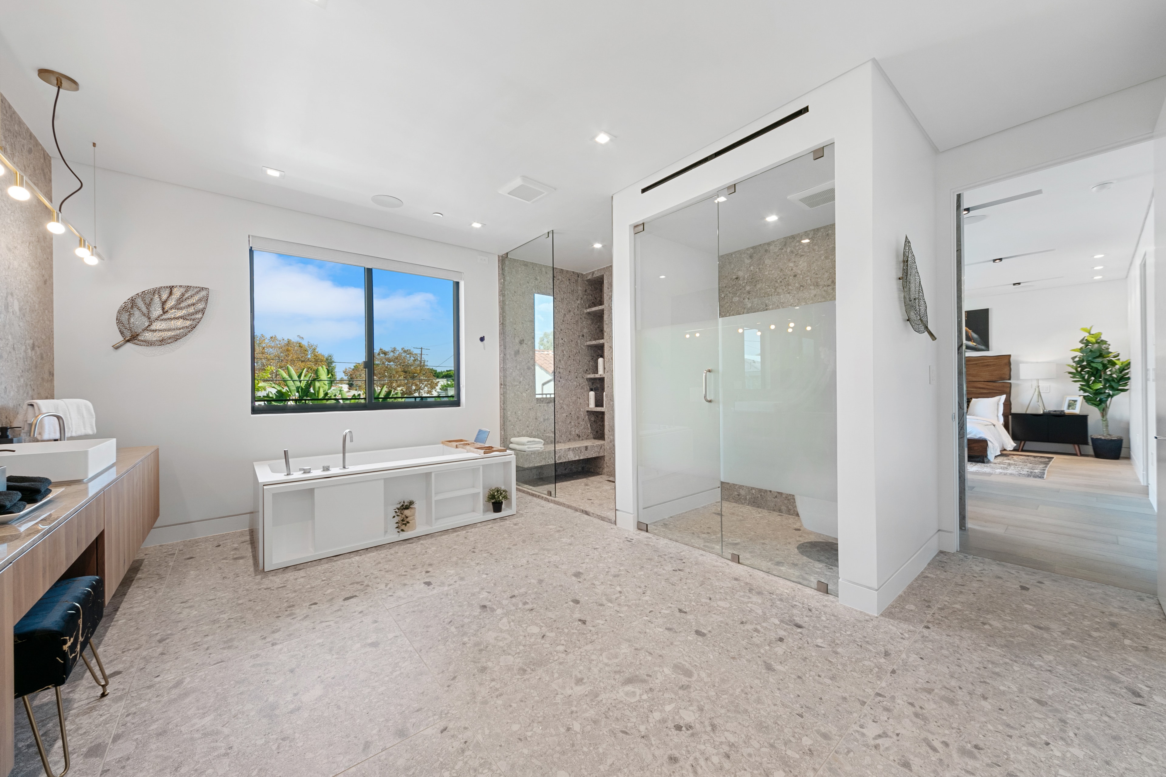 Primary bathroom with freestanding tub, glass shower, and stone flooring