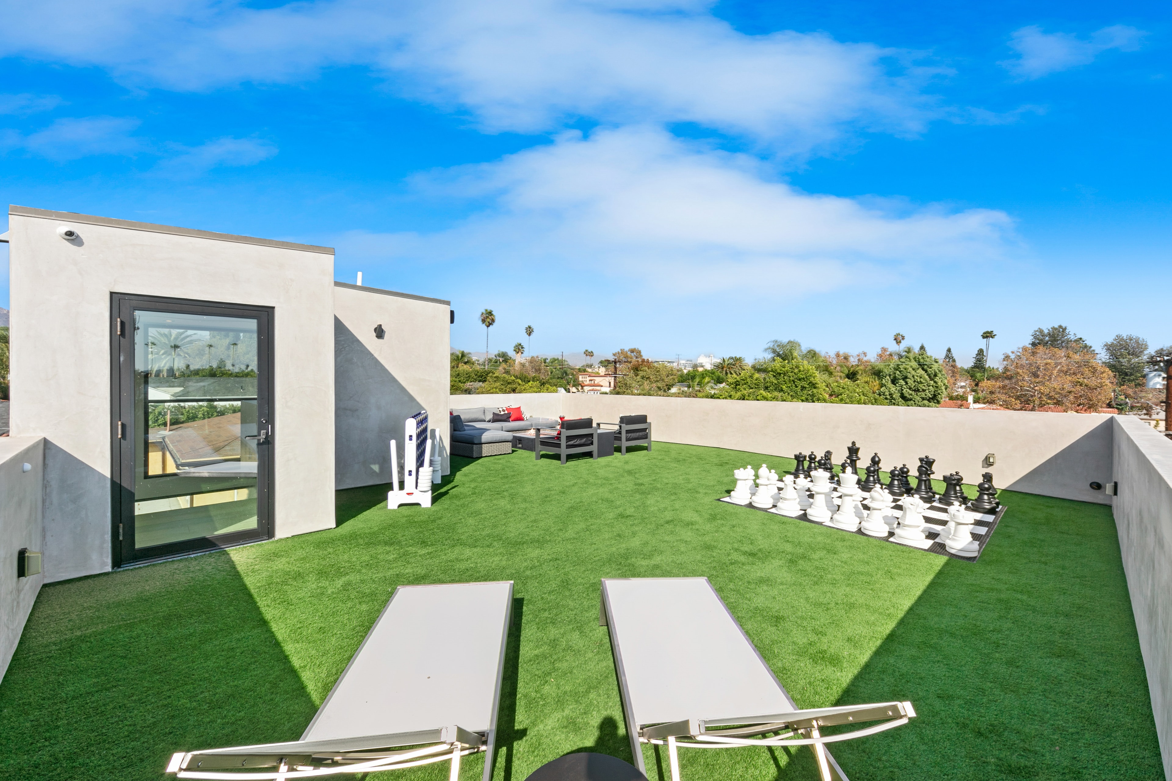 Rooftop lounge with fire table, oversized chessboard, and Los Angeles views