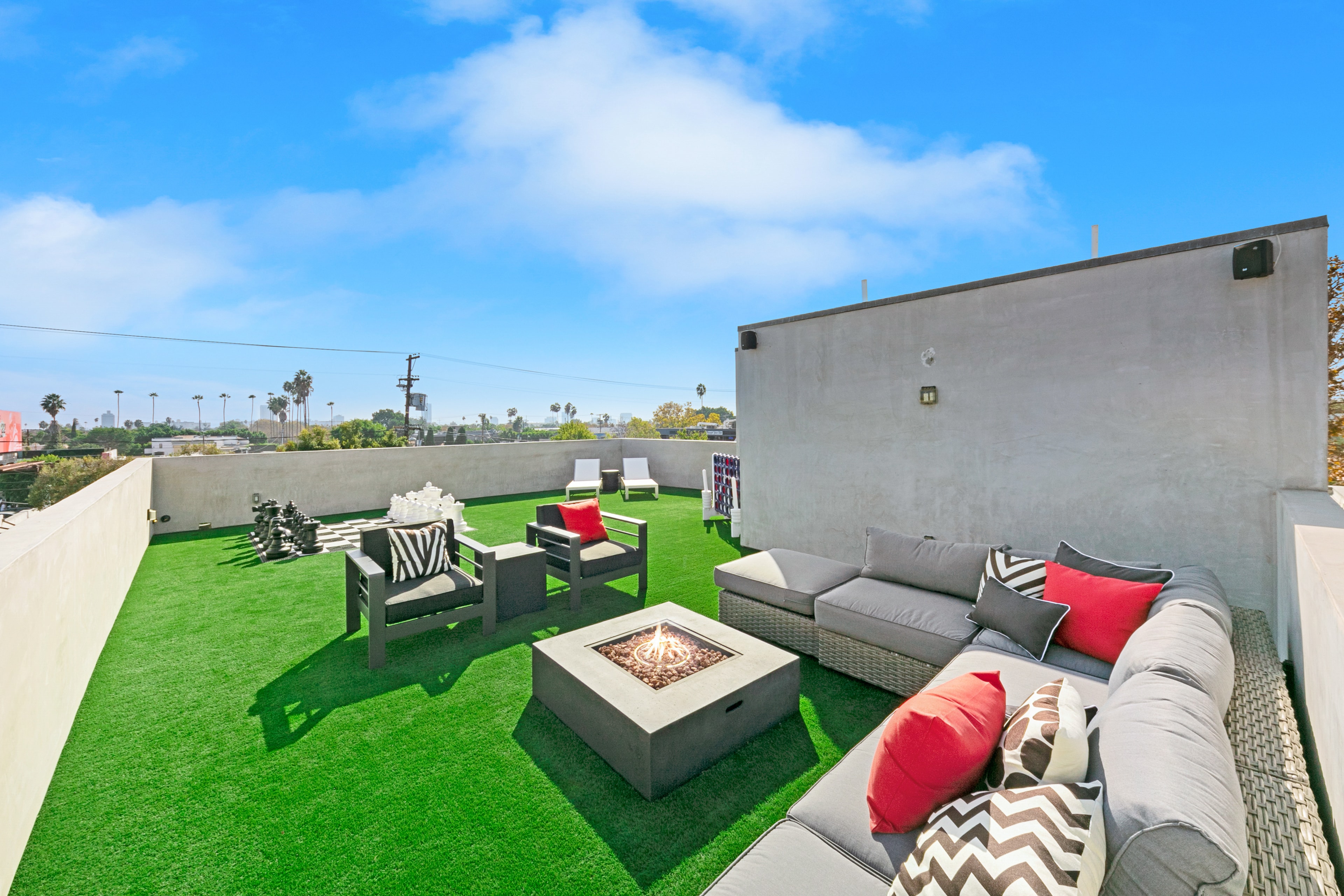 Rooftop terrace with fire pit, lounge seating, oversized chess, and city views