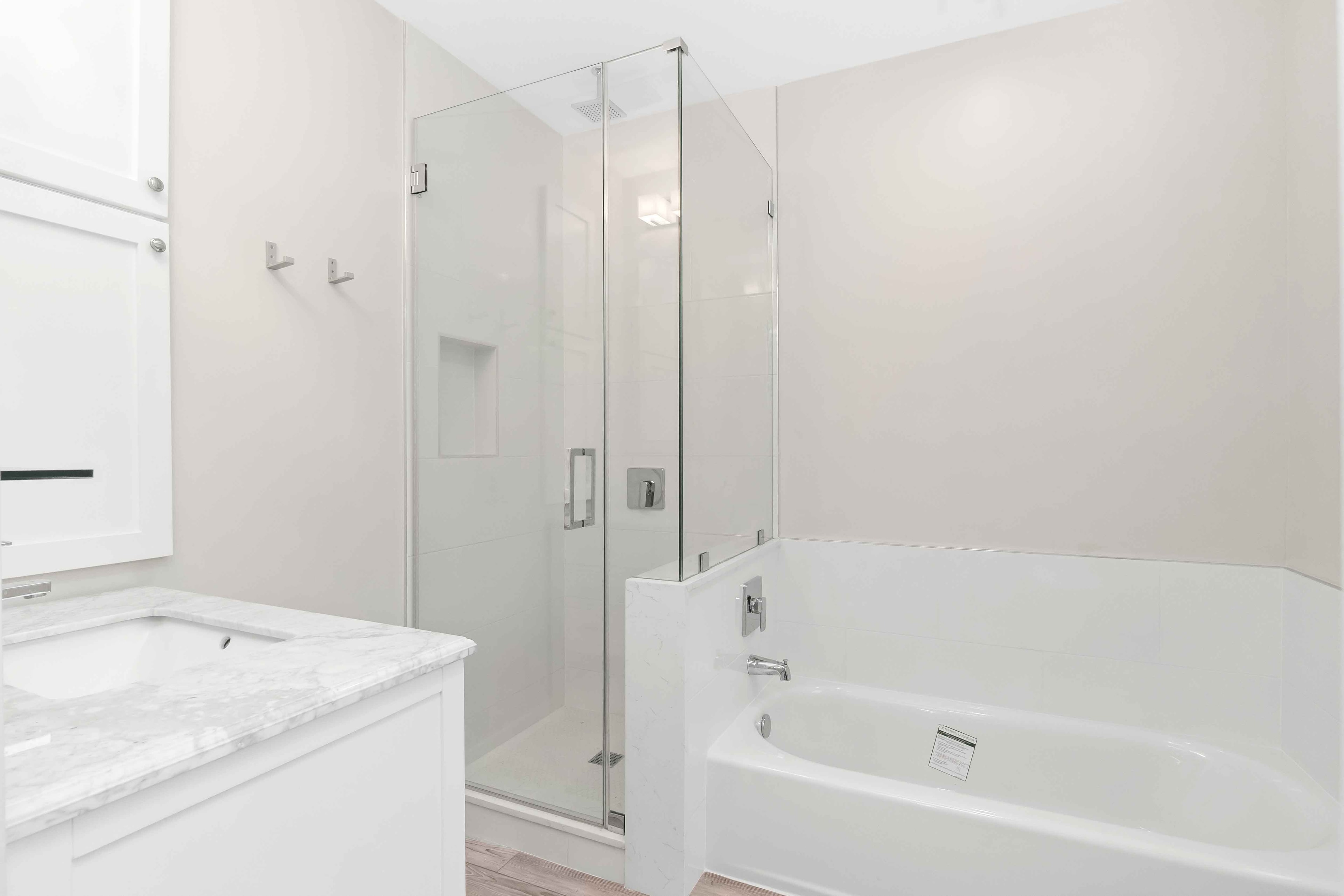 Bright remodeled bathroom with a soaking tub and glass-enclosed shower