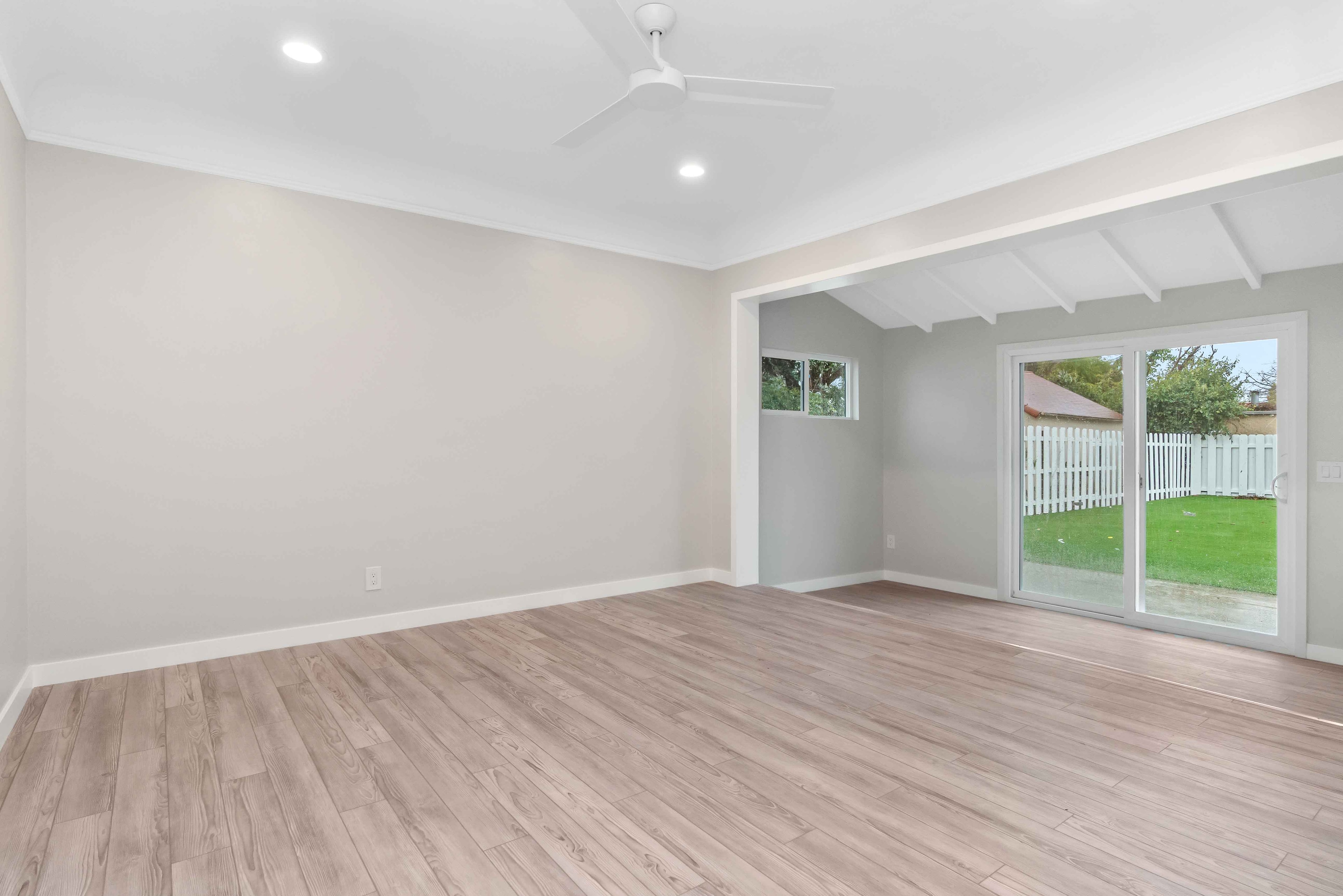 Bright family room with sliding glass doors opening to a fenced yard