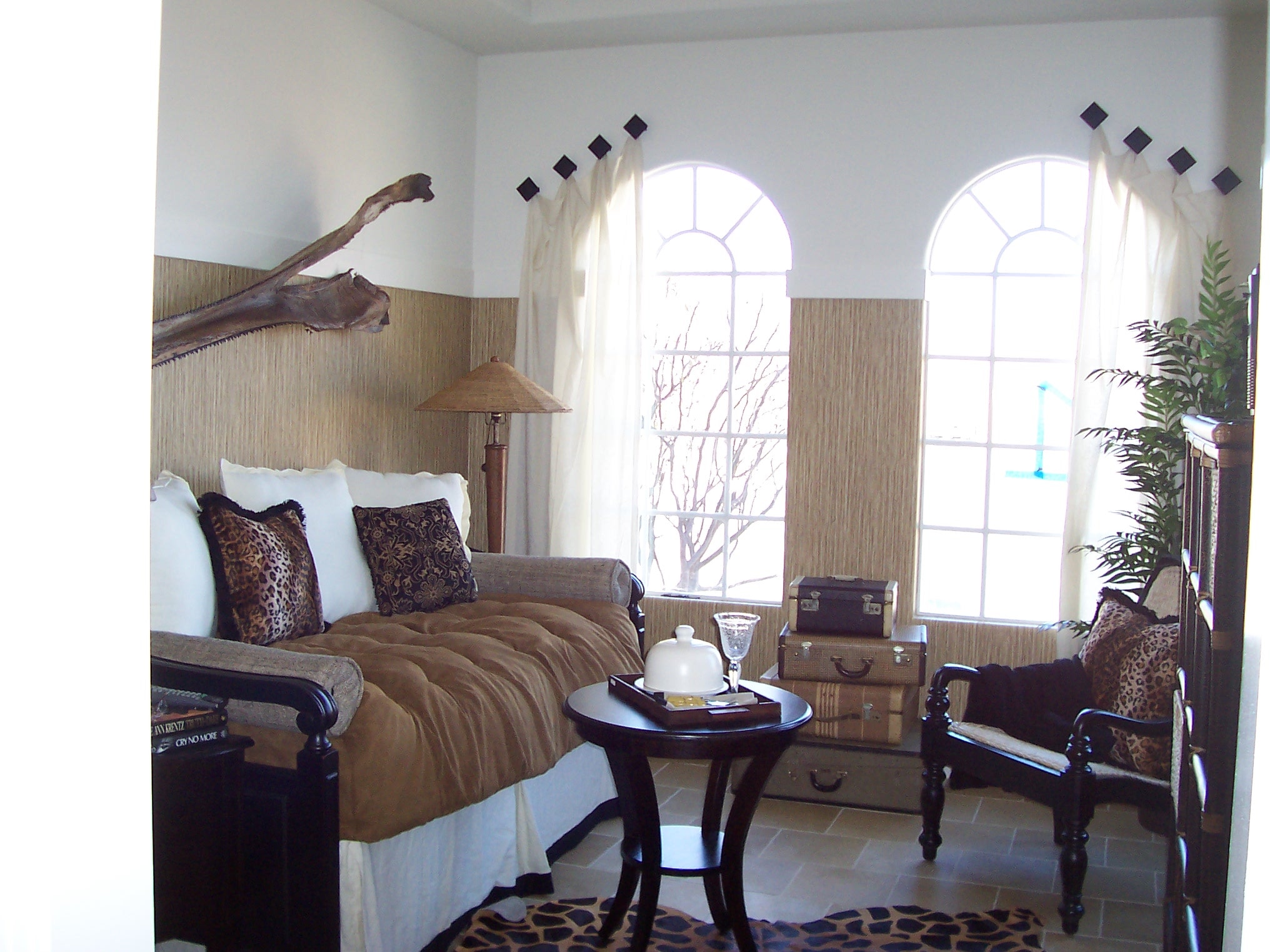 Bedroom with arched windows, leopard-print accents, and layered textiles