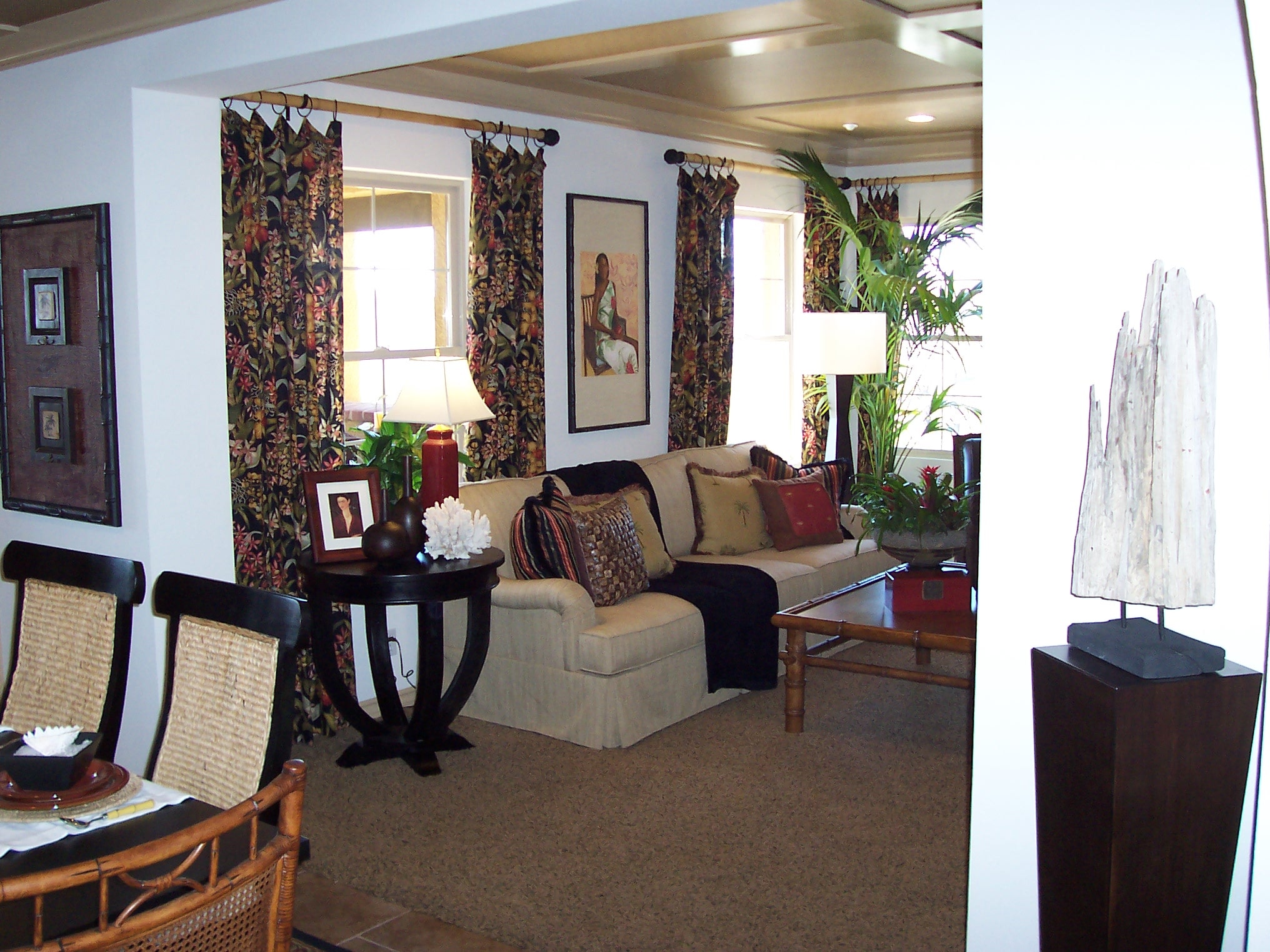 Living and dining room with patterned drapery and layered furnishings