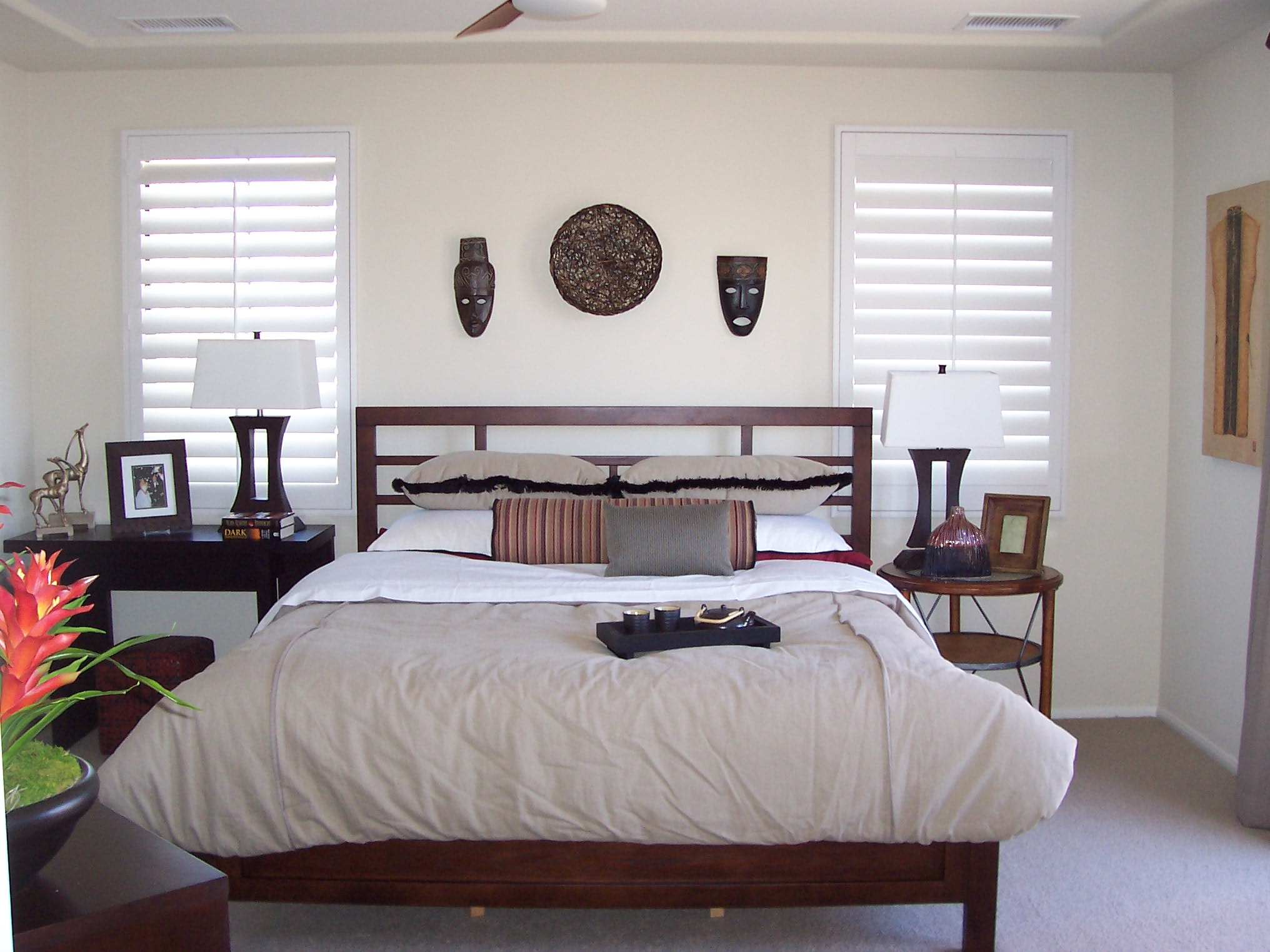 Neutral bedroom with dark wood bed frame and sculptural wall decor