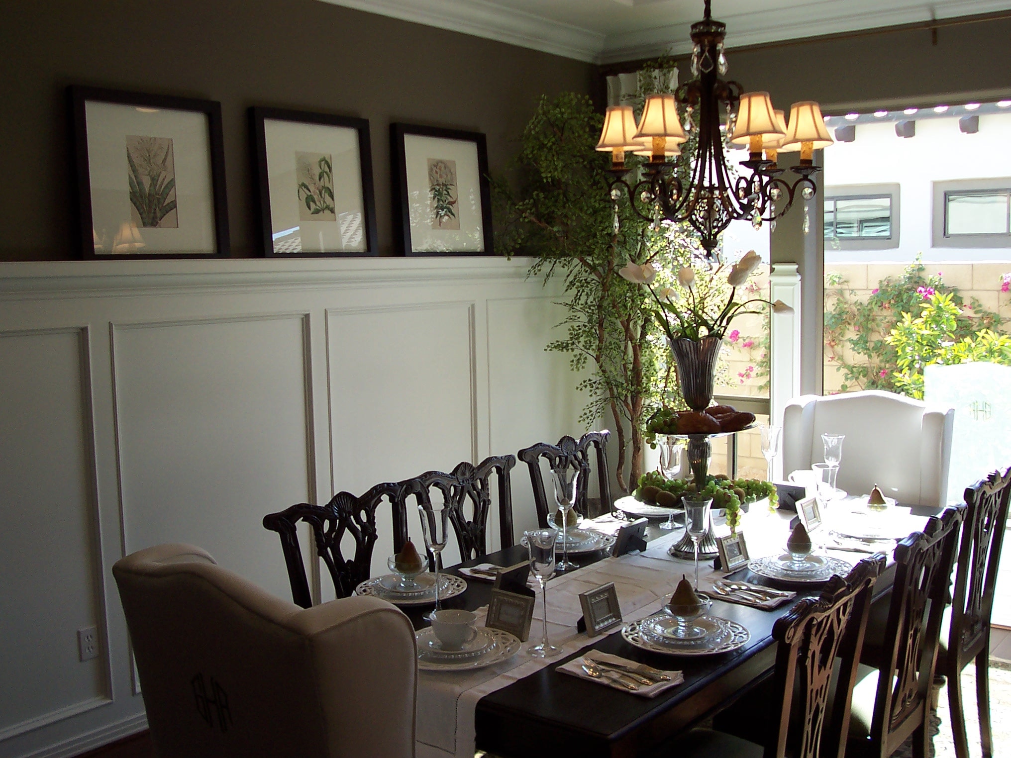 Formal dining room with dark wood chairs and botanical artwork