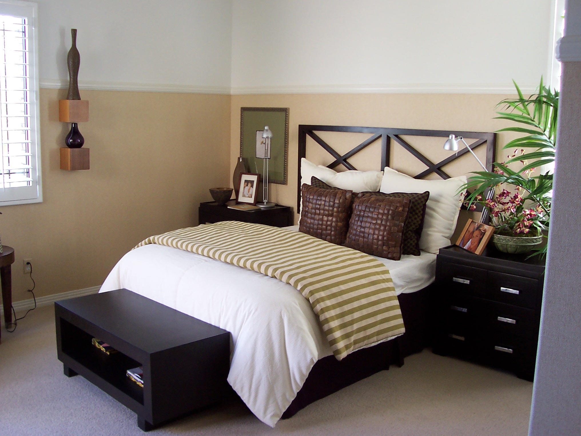 Bedroom with dark wood furniture, white bedding, and a striped throw