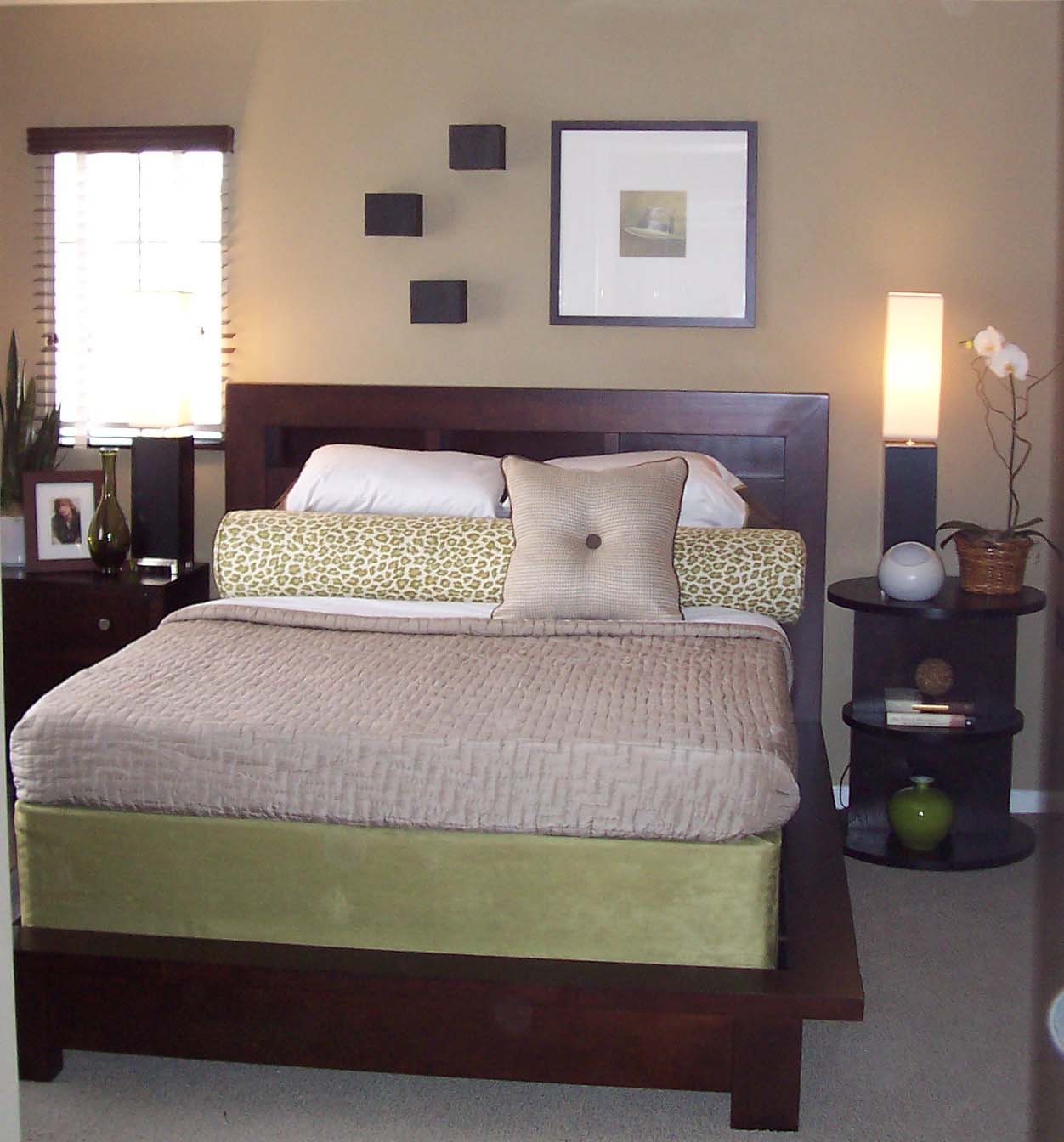 Neutral bedroom with dark wood furniture and green accents