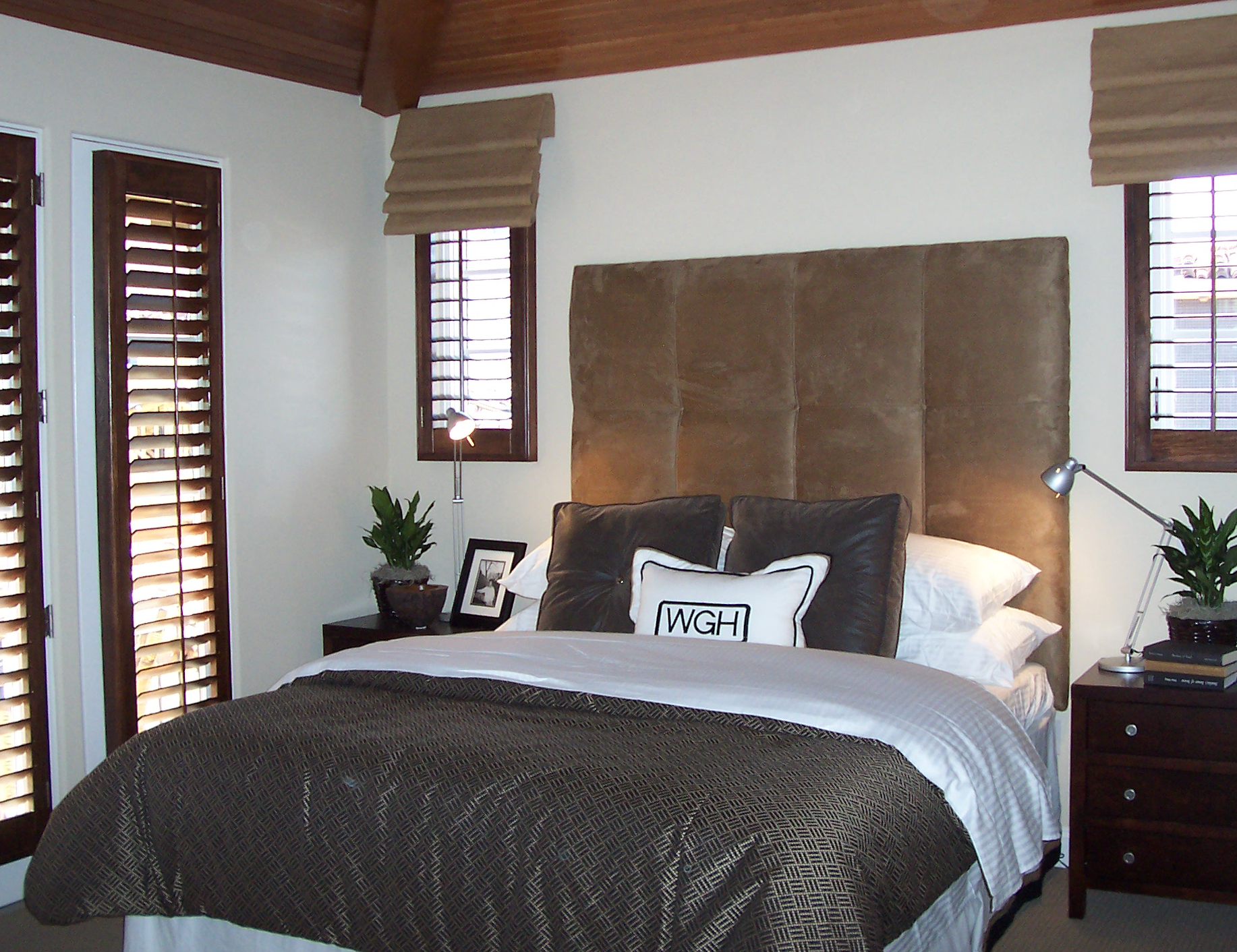 Bedroom with leather headboard and neutral furnishings
