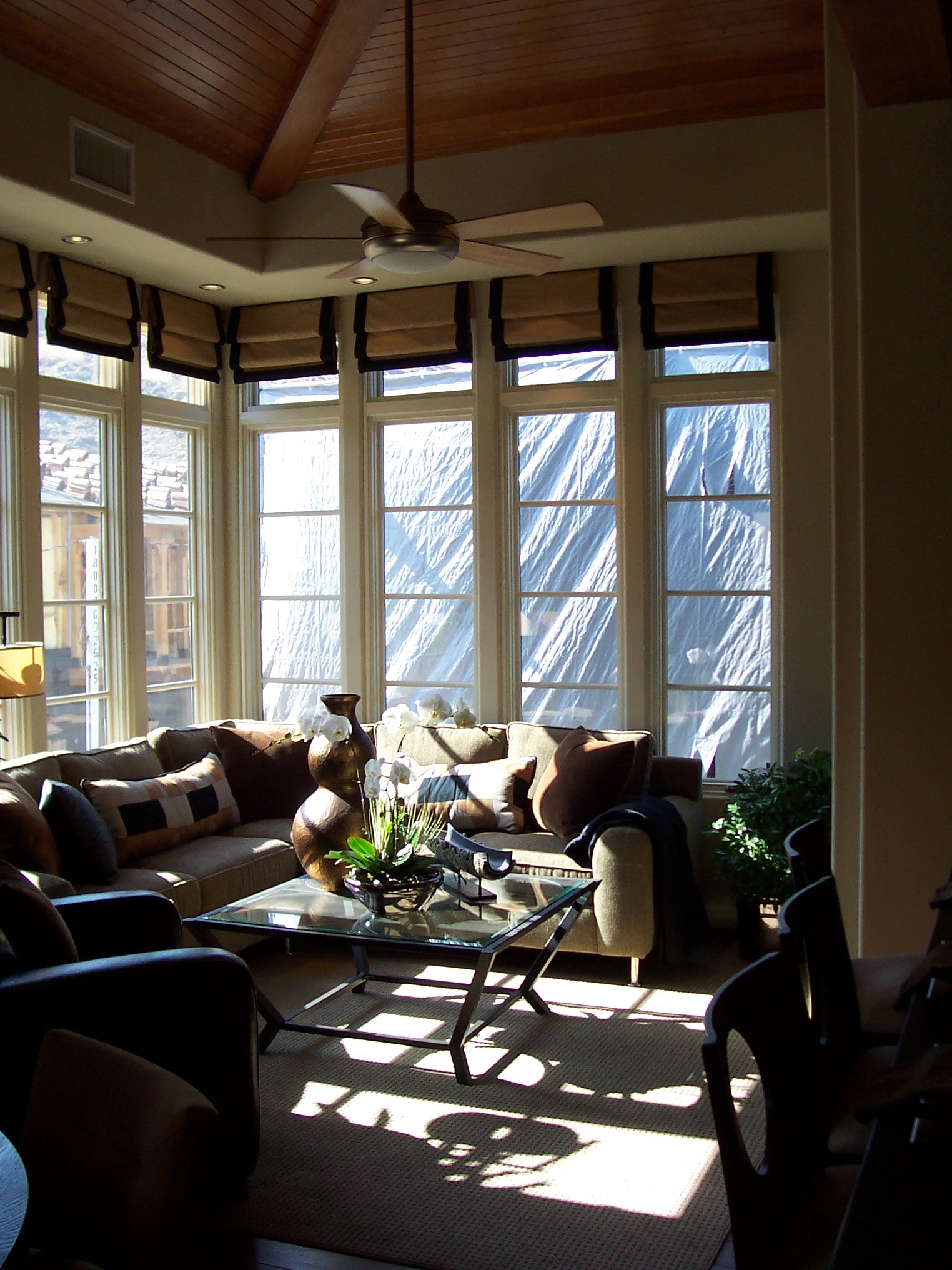 Sunlit living room with vaulted wood ceiling and window wall